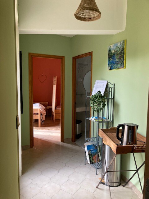 - Couloir cosy avec étagère métallique, bouilloire, tableau coloré et accès aux pièces.
