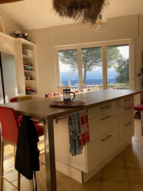 Cuisine ouverte avec vue sur lac ou montagne, îlot central et déco chaleureuse.