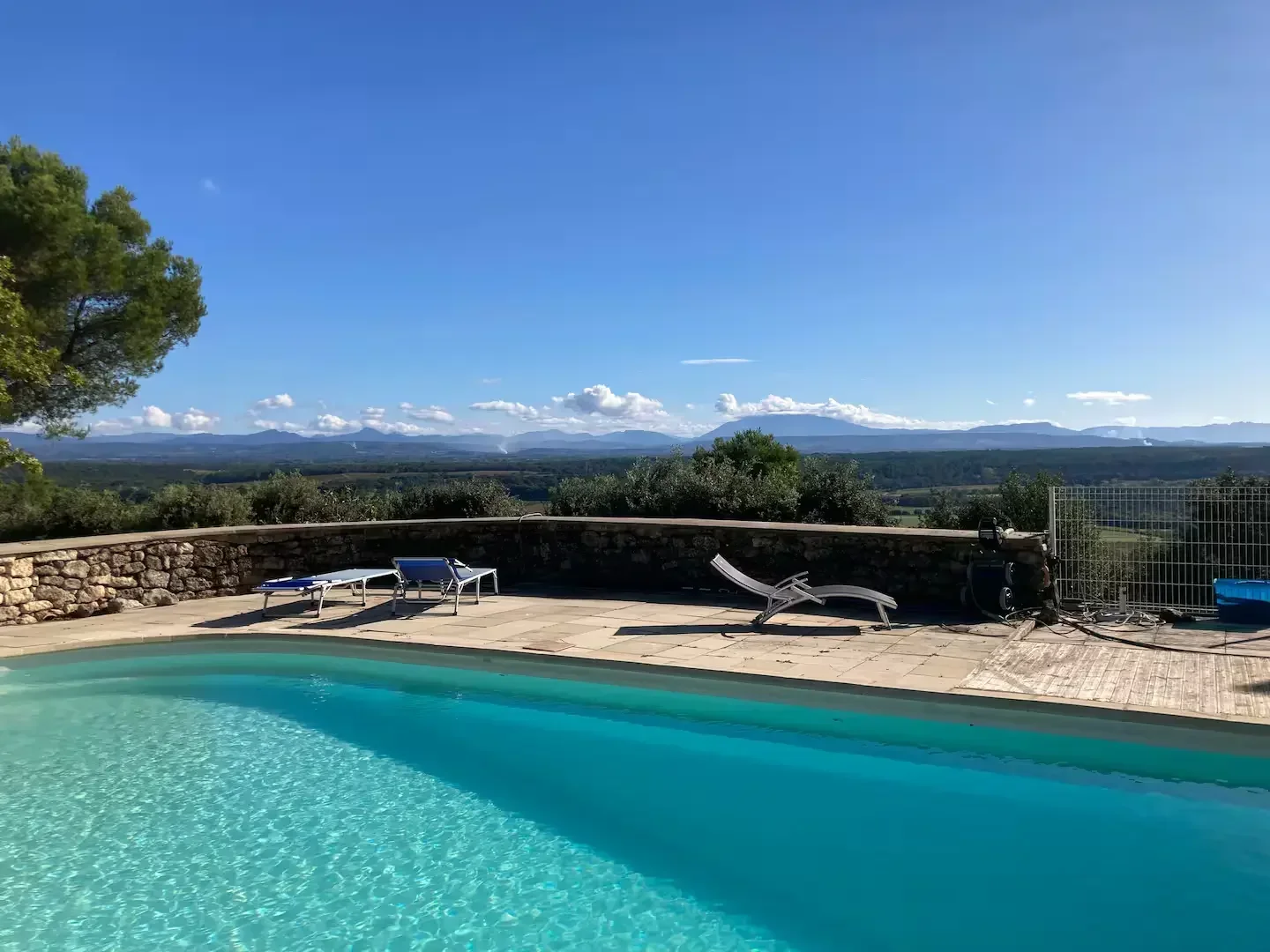 Bassin de nage extérieur et transats donnant sur le jardin avec D'ensemble D'une Bois Turquoise Table Dressée Arboré Sous Ciel Bleu